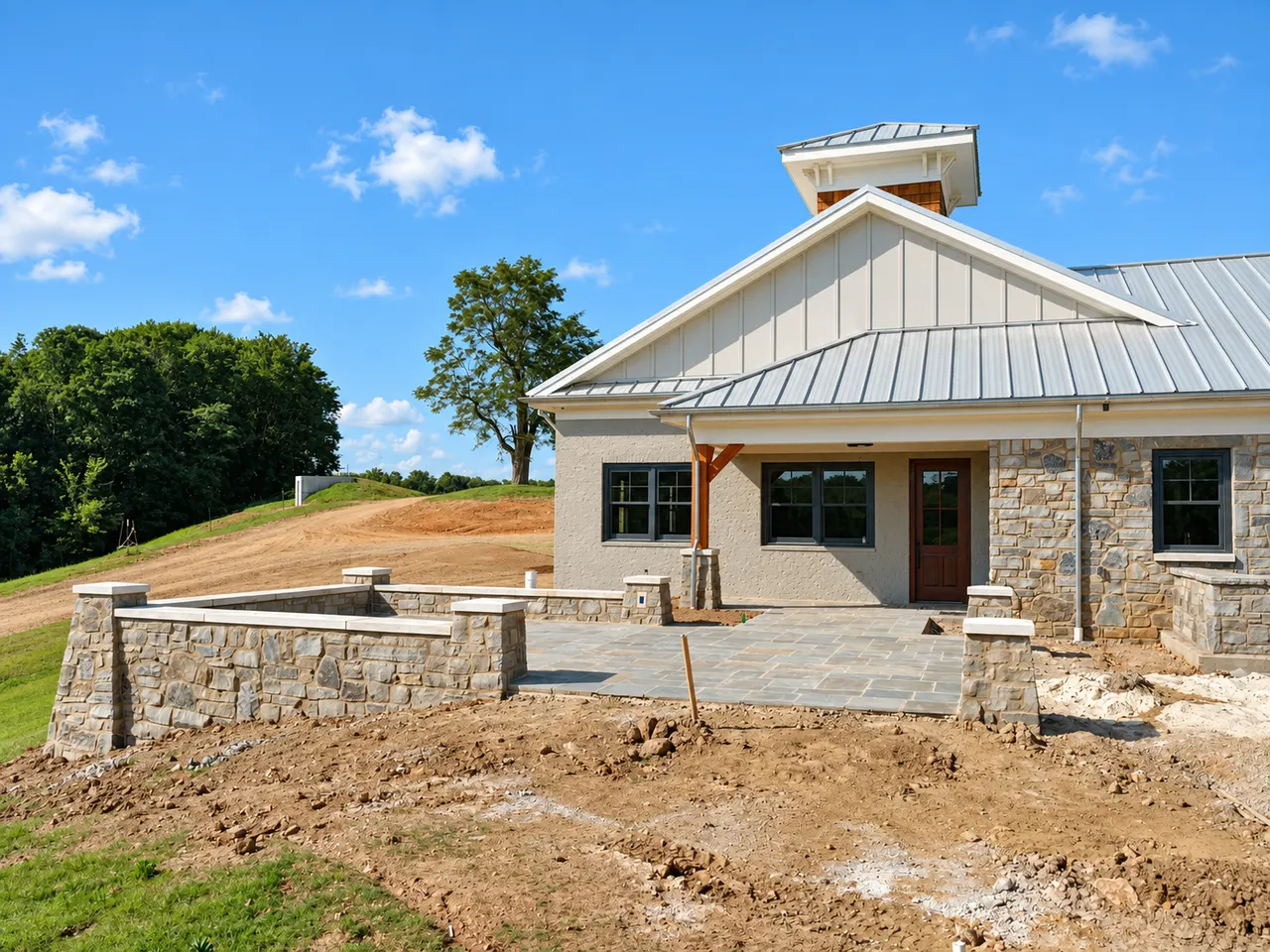 Custom home site with graded areas and stone retaining walls prepared for exterior hardscape and landscaping.