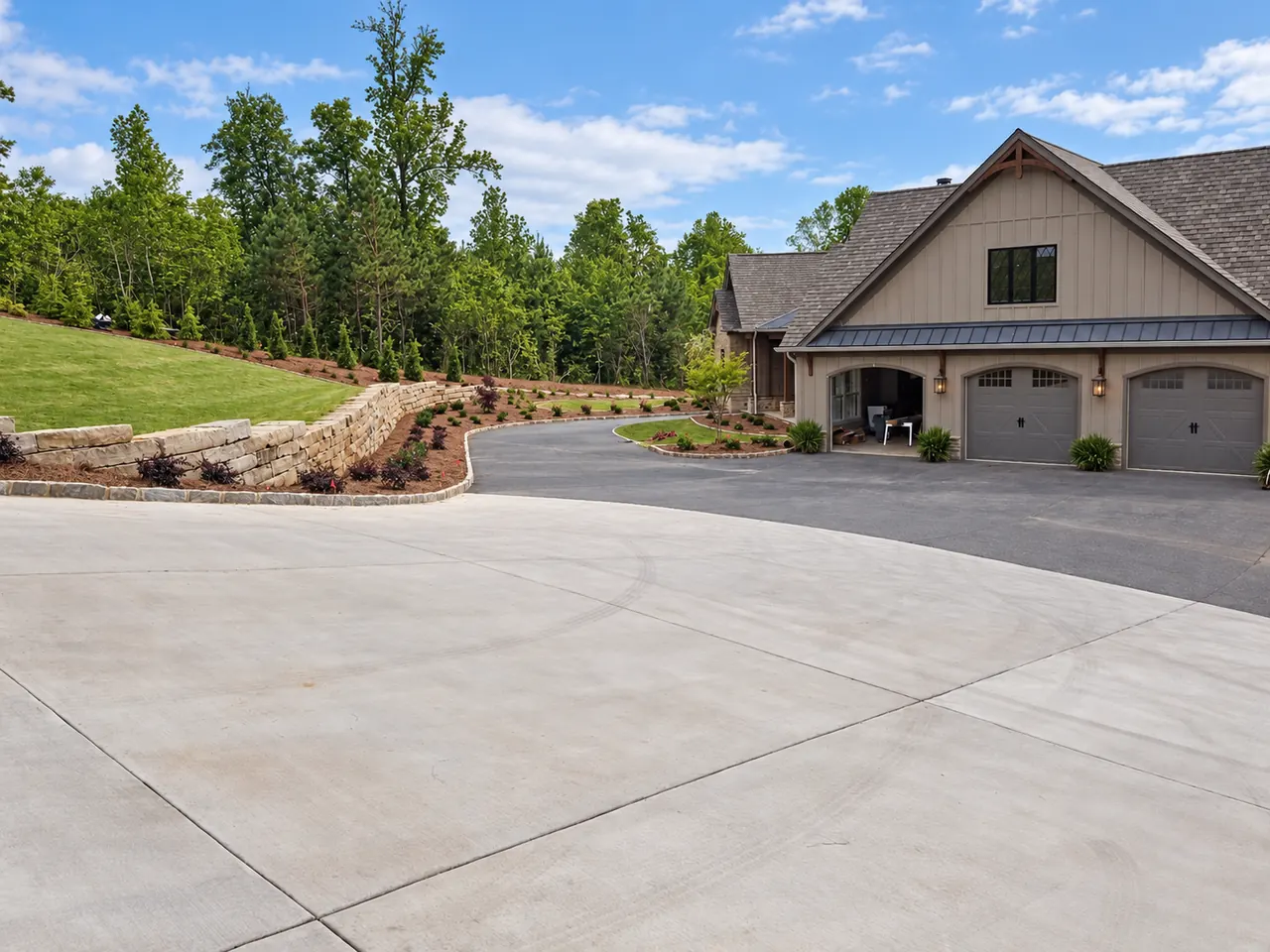 Finished driveway and stone landscape walls at a lake house after grading and site preparation.