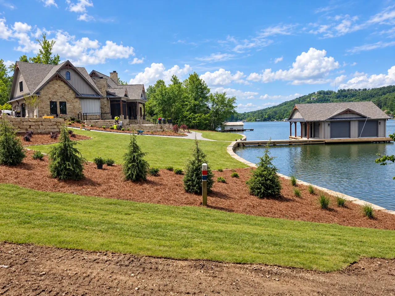 Finished lakefront landscape showing graded lawn, shoreline improvements and coordinated site work around a Guntersville home.