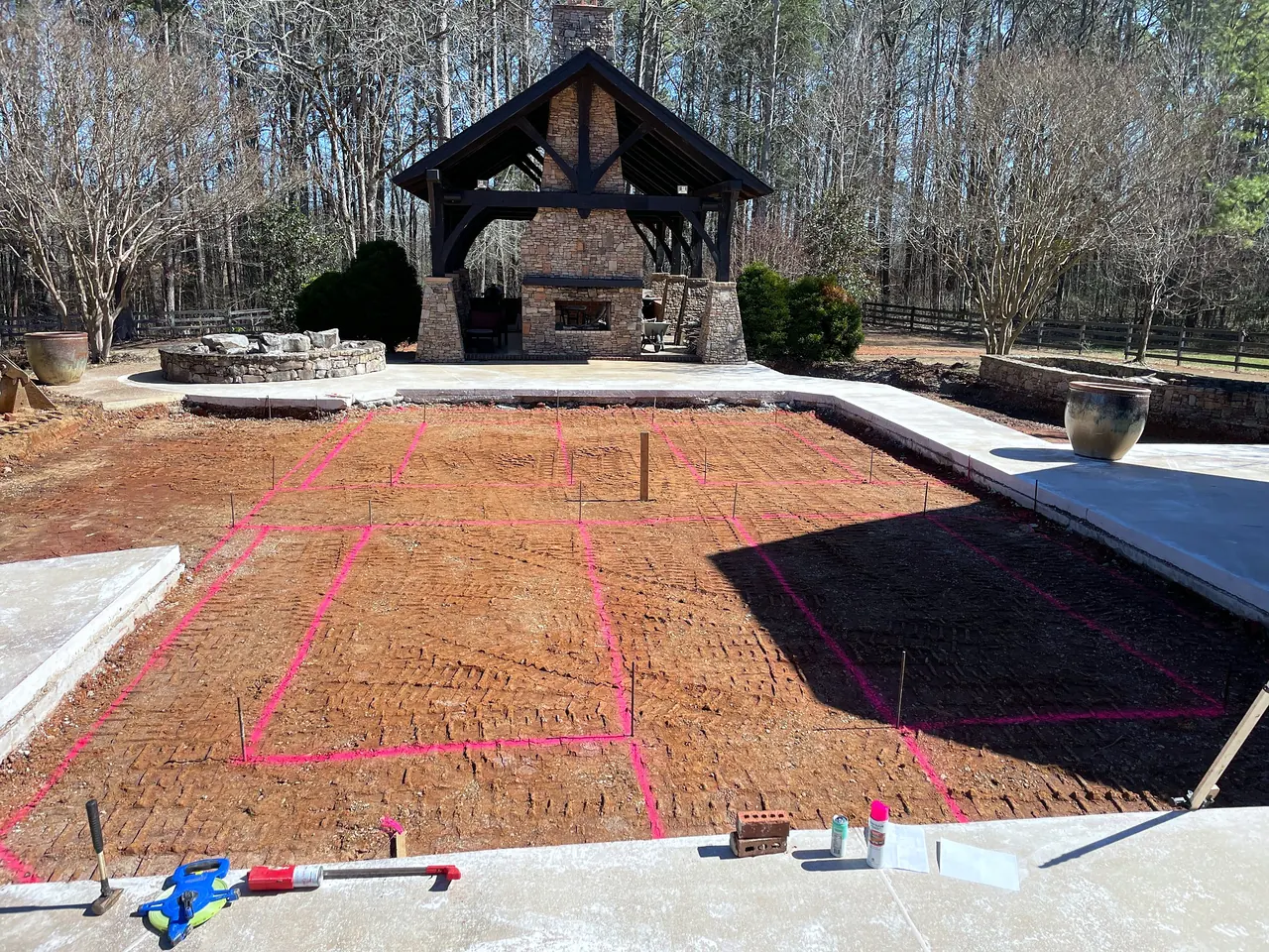 Former pool area after removal, grading and layout marking for new raised planting beds.