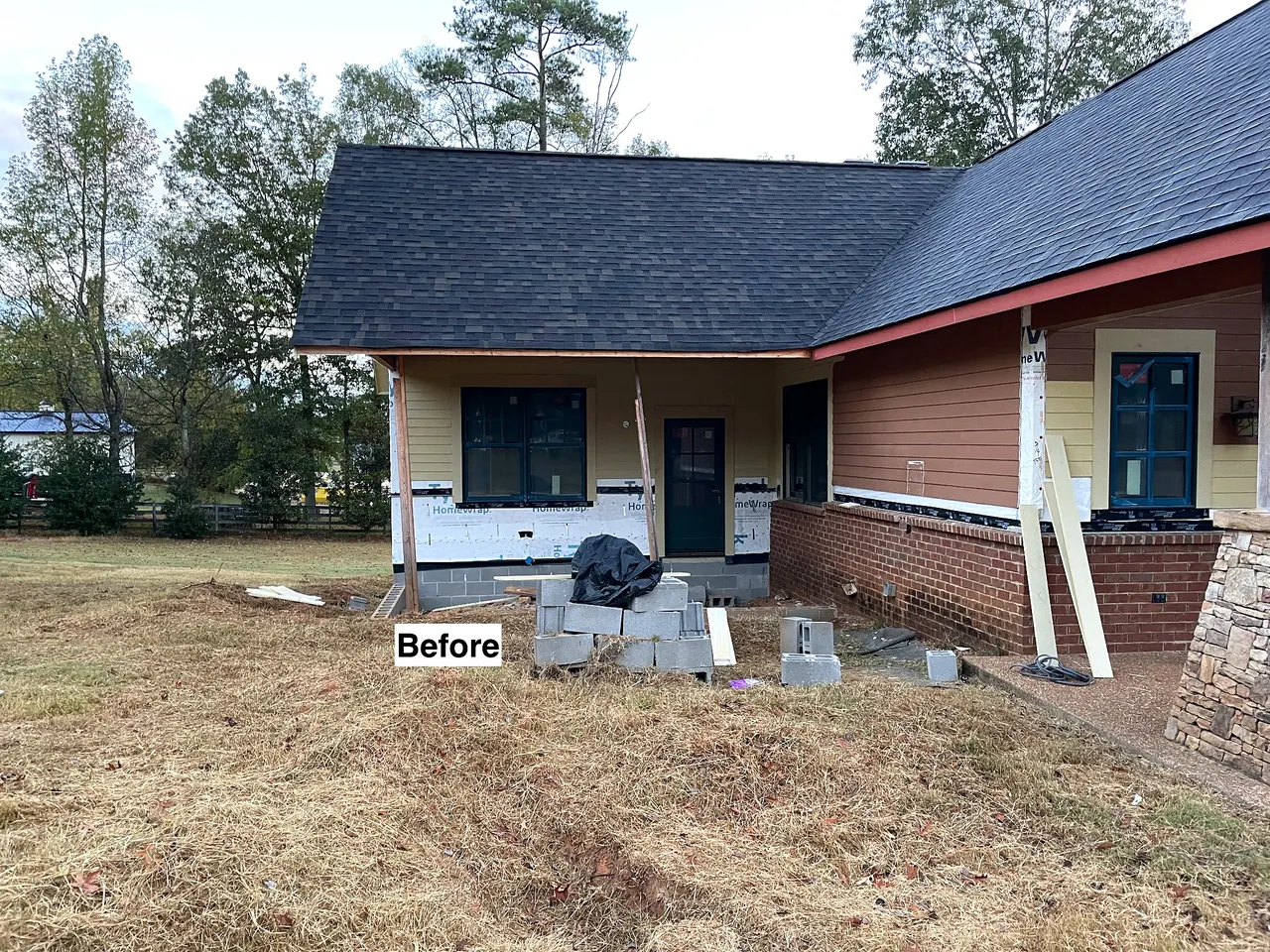 Back of a ranch residence before grading and site preparation for a new porch and hardscape.
