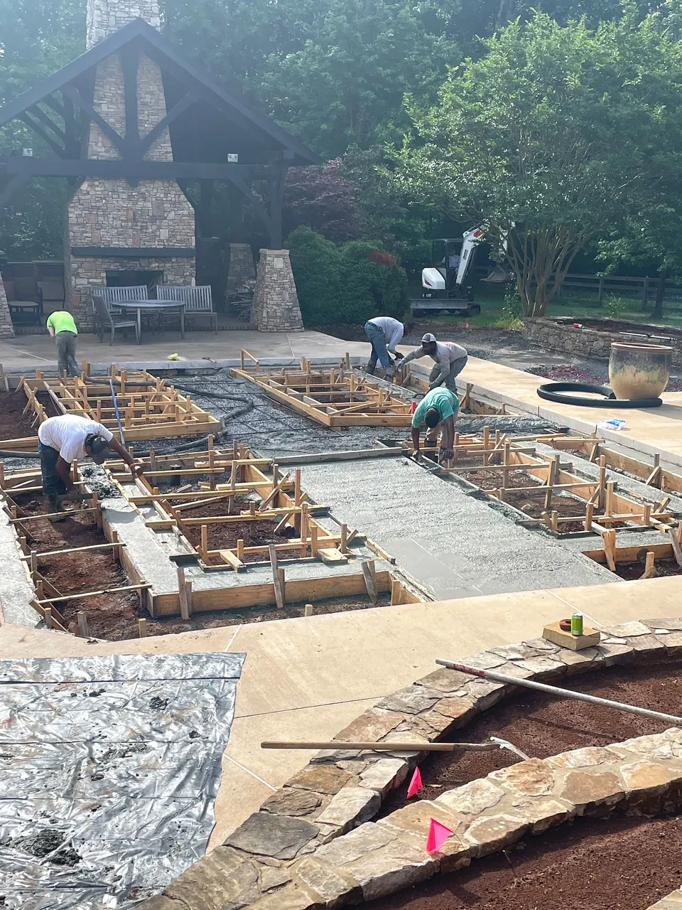 Concrete work in progress for new raised planting beds at the former pool site.