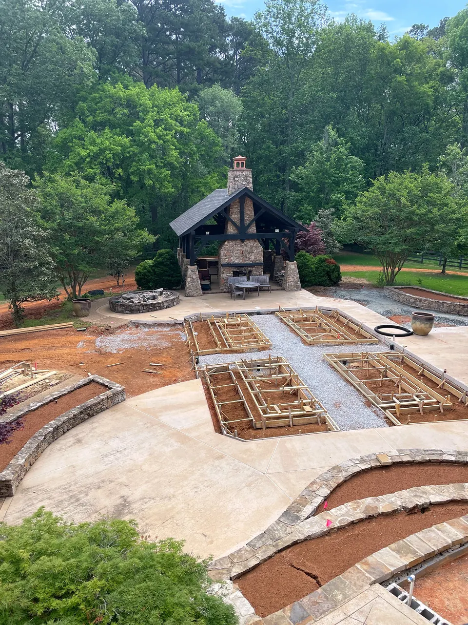 Raised planting bed forms under construction after pool removal and site reconfiguration.